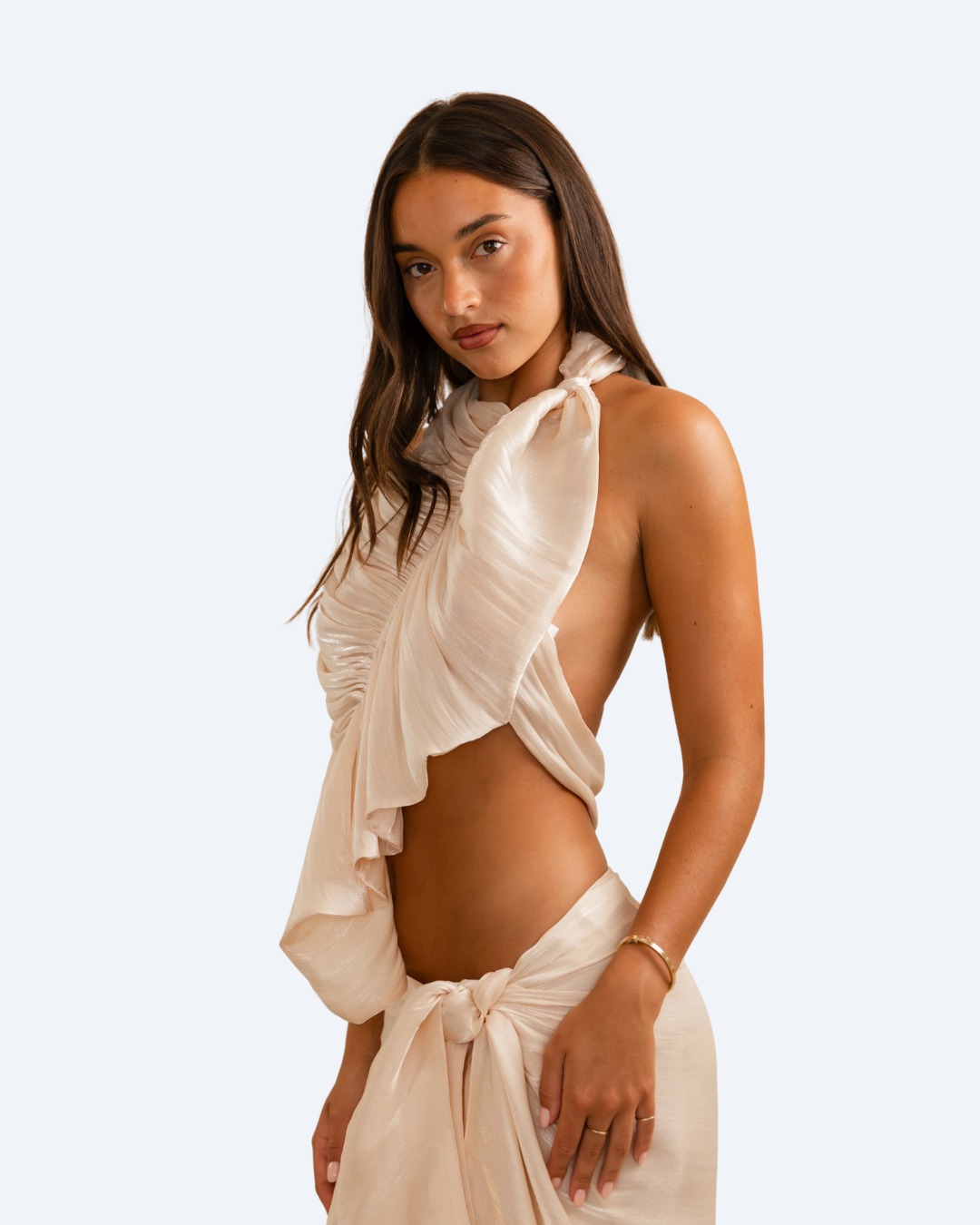 Woman wearing Koster Kulture champagne bobbie ruffled top and skirt set on light gray background, stylish two-piece outfit. front view.