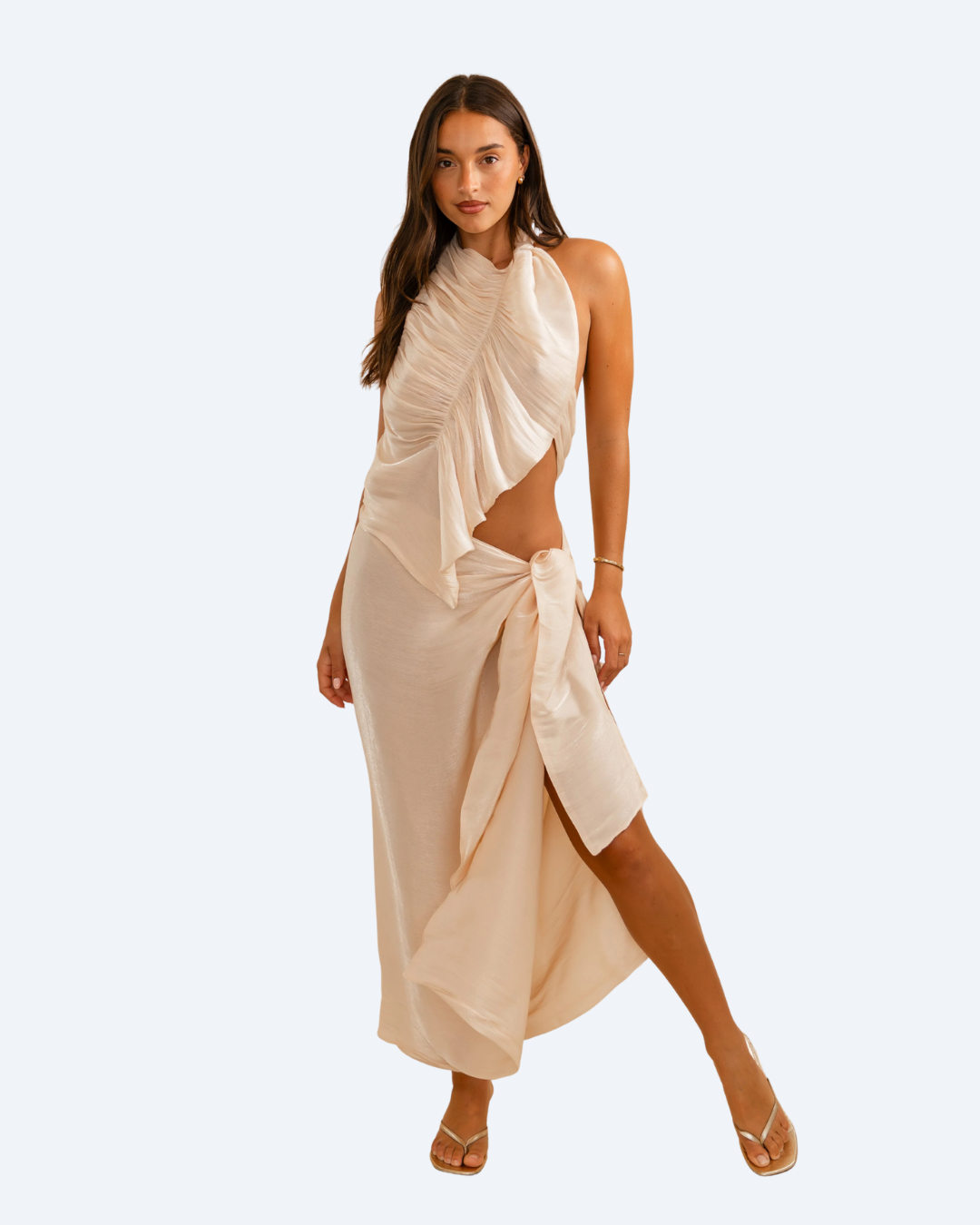 Woman wearing Koster Kulture champagne bobbie top and skirt set on light gray background, stylish two-piece outfit. front view.