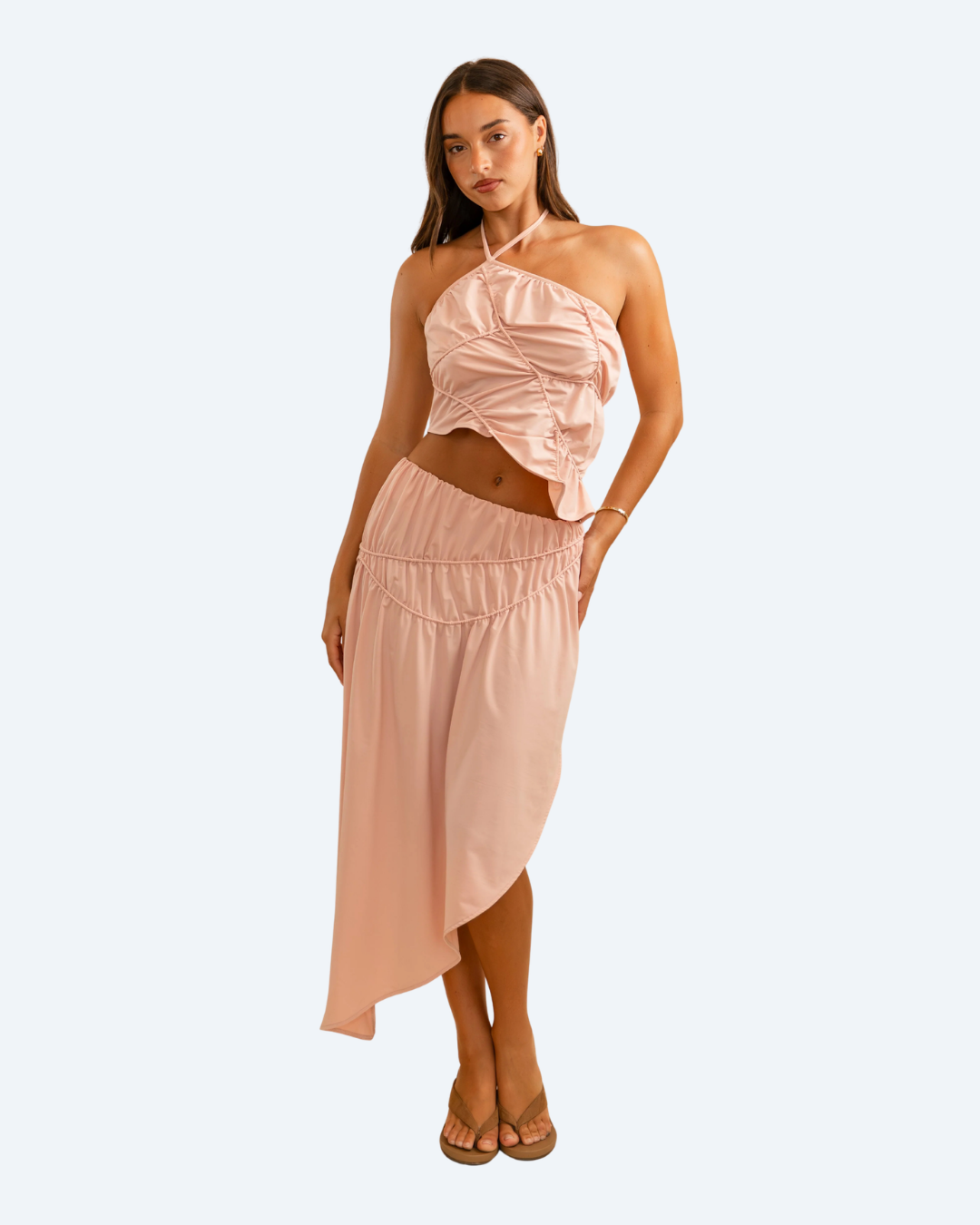 Woman wearing Koster Kulture pink fleur top and skirt set on light gray background, stylish two-piece outfit. front view.