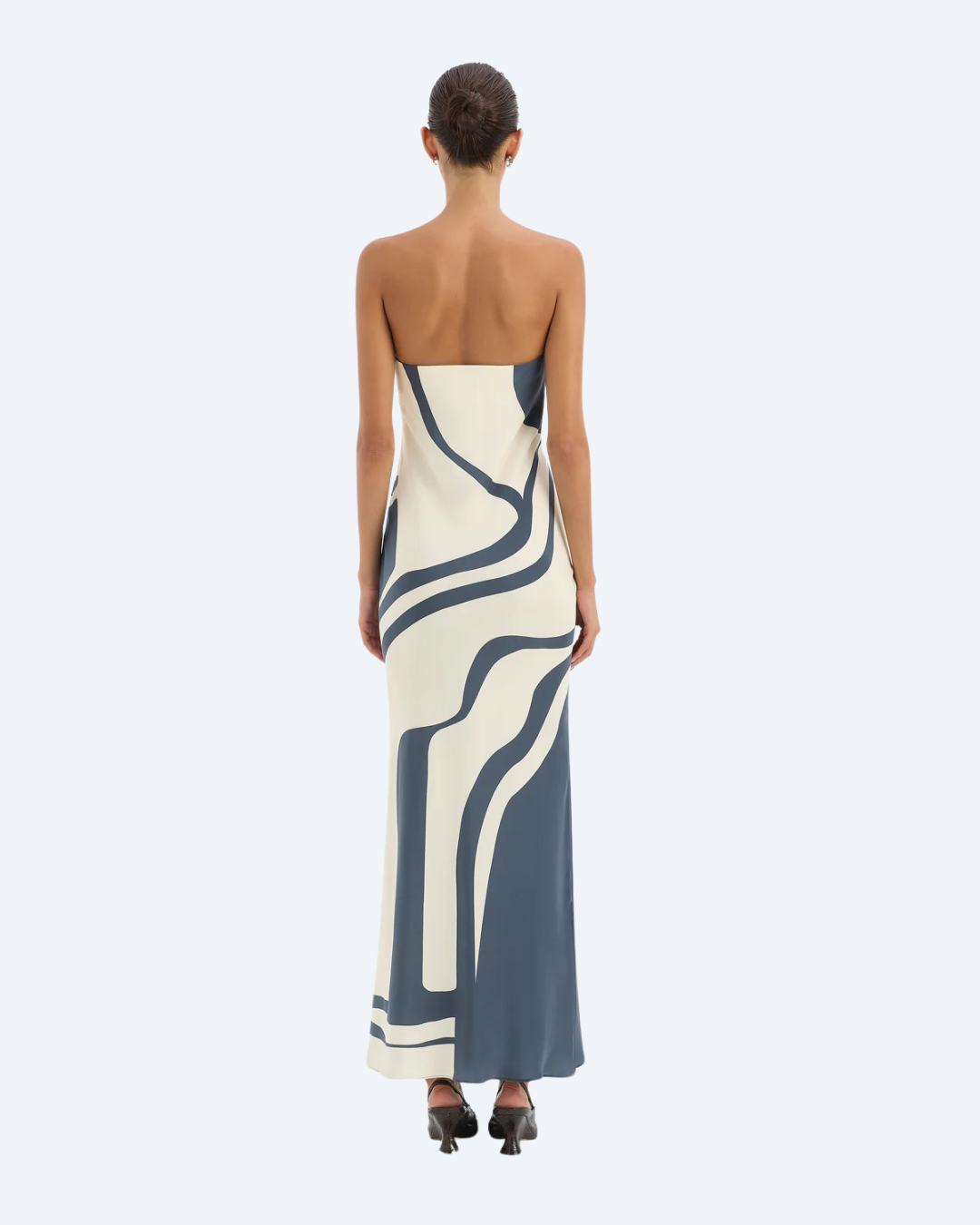Woman wearing Sir the Label Lilou strapless dress with abstract pattern, back view, on a white background