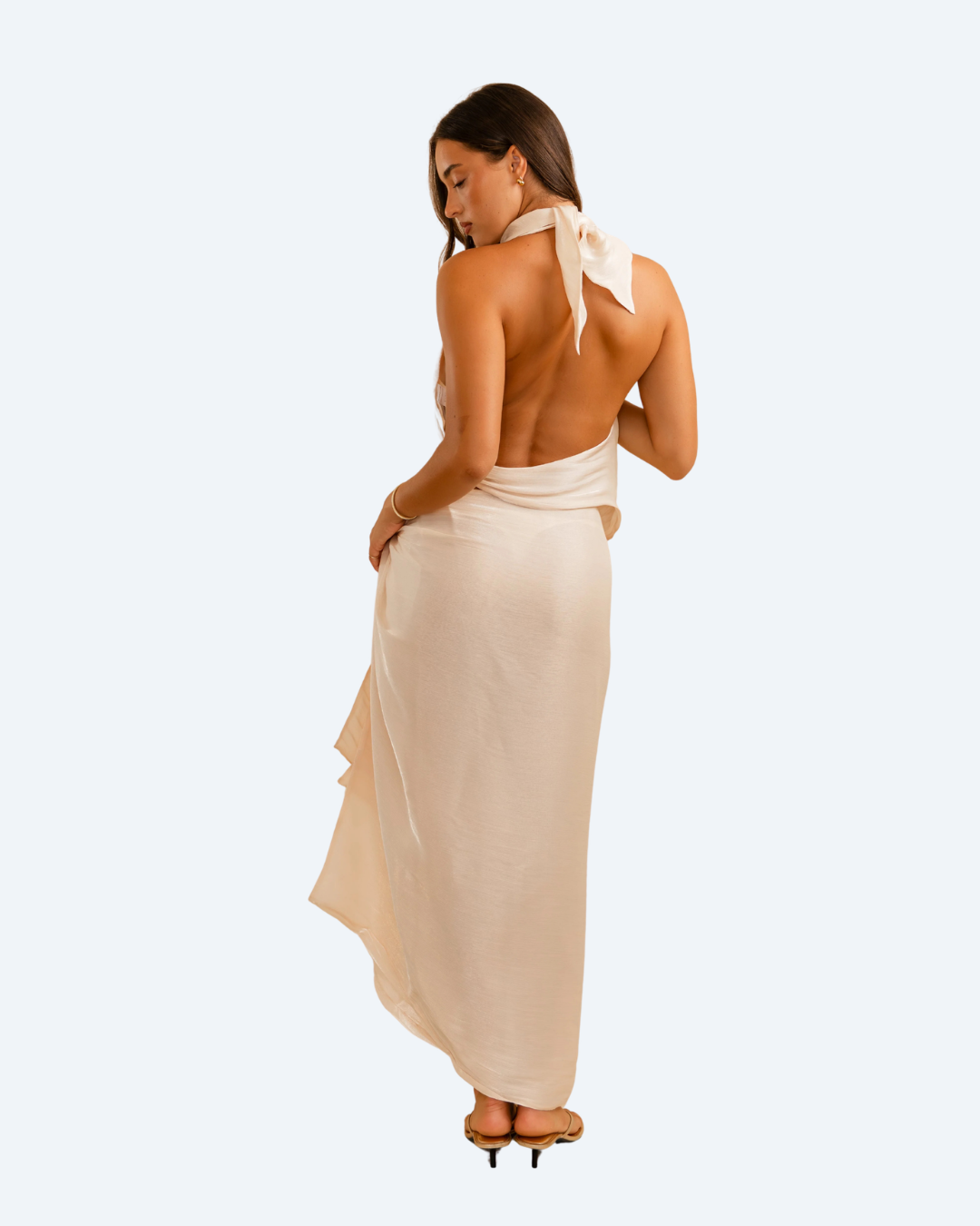 Woman wearing Koster Kulture champagne bobbie top and skirt set on light gray background, stylish two-piece outfit. back view.