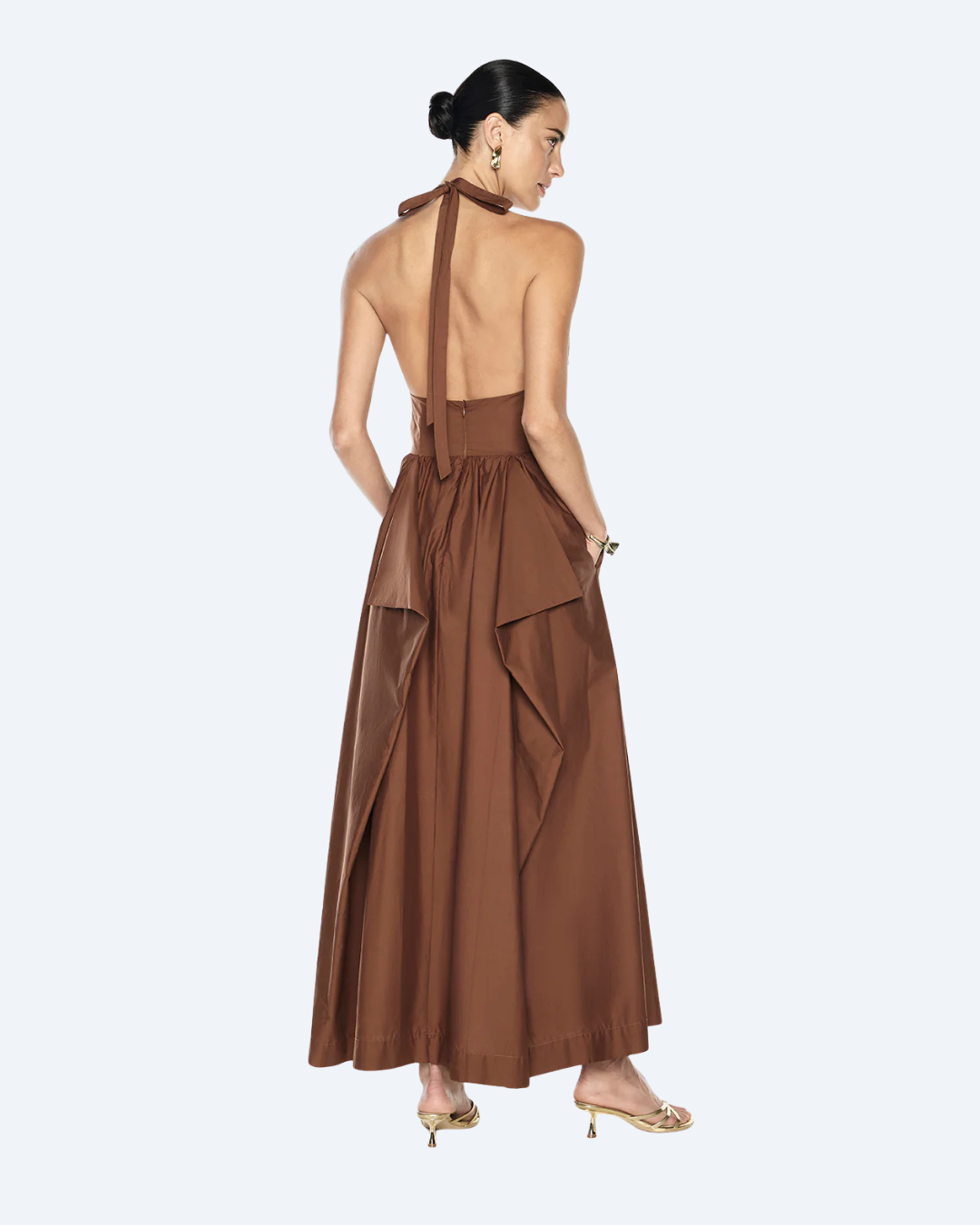 Woman wearing a cognac Manning Cartell Provence halter dress, back view, on a white background.