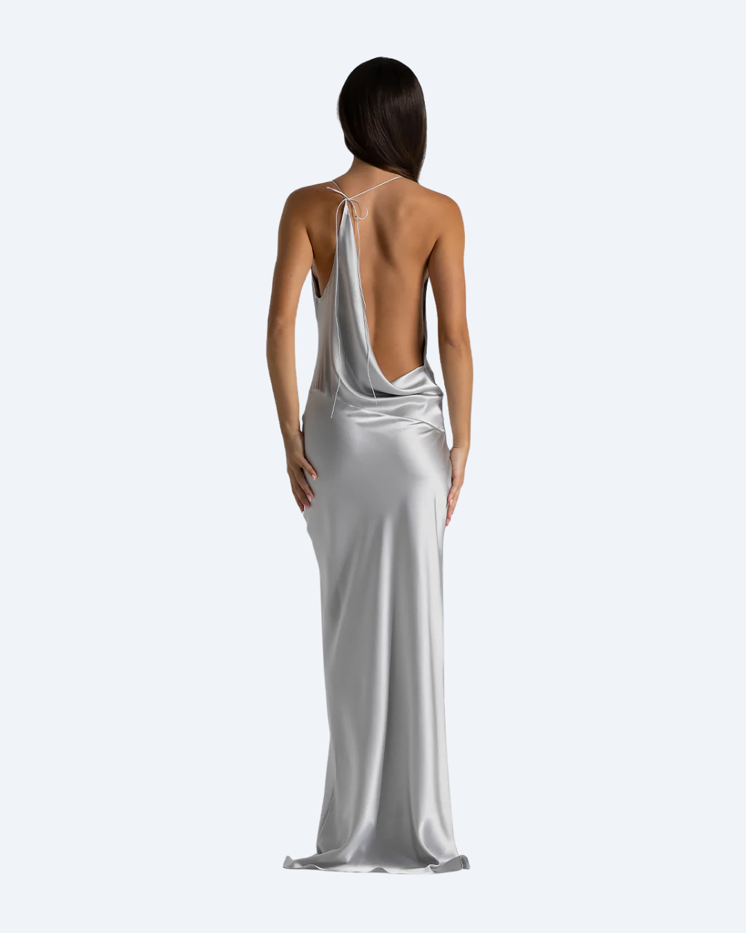 Woman wearing the Gabi Gown by Natalie Rolt, a silver satin back view dress on a white background
